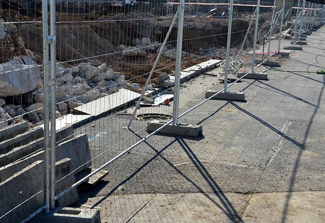 a row of temporary fence panels enclosing a job site